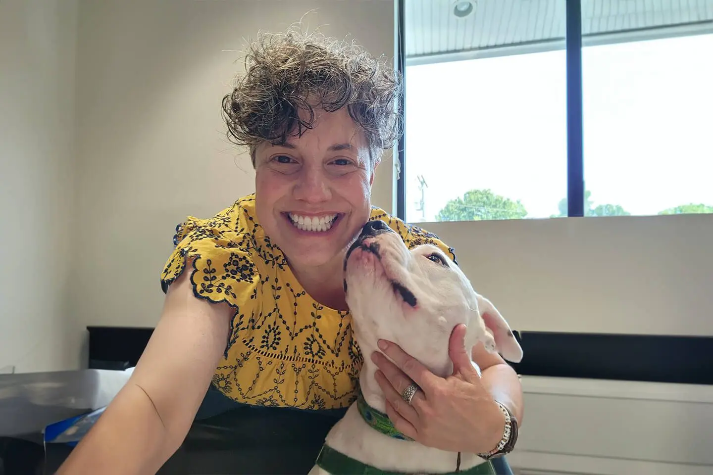 A woman holding a dog in her mouth.