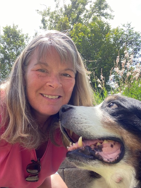 A woman and her dog are smiling for the camera.