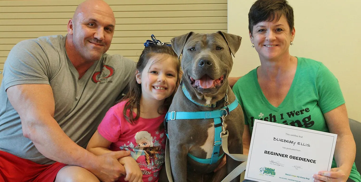 A family posing with their dog at the vet.